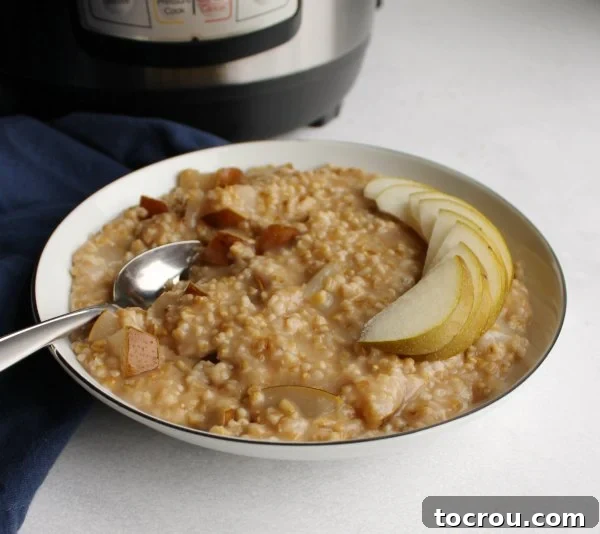Instant Pot Steel Cut Oatmeal with Honey and Pears Bowl of steel cut oatmeal with honey and pears in front of Instant Pot, garnished with fresh pear slices and a drizzle of honey.