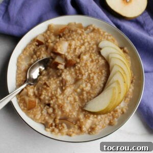 Instant Pot Honey Pear Oatmeal Instant Pot steel cut oatmeal with honey and pears in bowl served with slices of fresh pear on top, ready to eat.