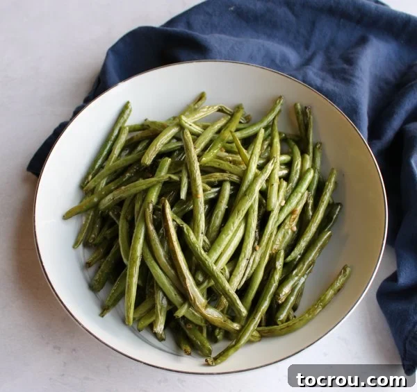 Bowl of perfectly roasted green beans, tender-crisp and lightly blistered, ready to serve as a healthy side dish.