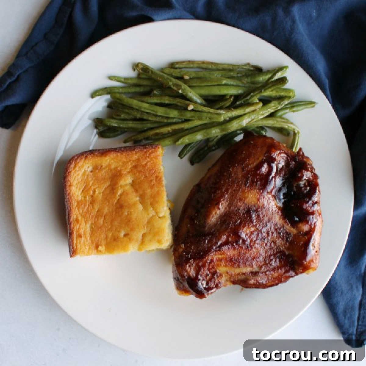 A complete meal: succulent oven-baked BBQ chicken, tender roasted green beans, and a comforting corn casserole.