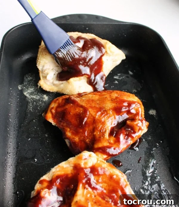 Applying BBQ Sauce to Baked Chicken brushing bbq sauce on to baked chicken breast.