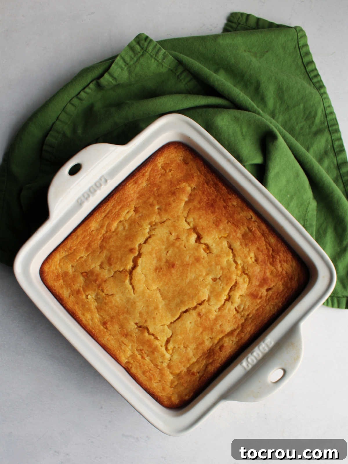 Golden Corn Delight 4 Square casserole dish of corn casserole, freshly baked from the oven with golden edges.
