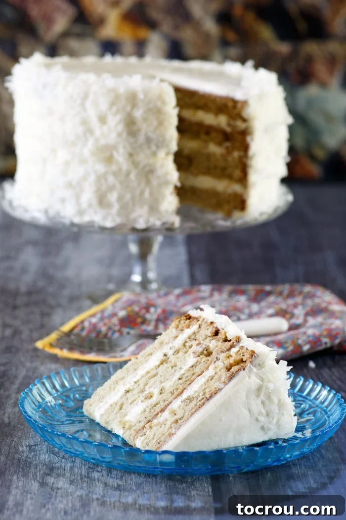 layered banana cake on stand with slice of cake served in front of it.