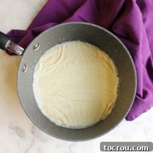 Gelatin Blooming in Milk gelatin blooming on top of milk in saucepan.