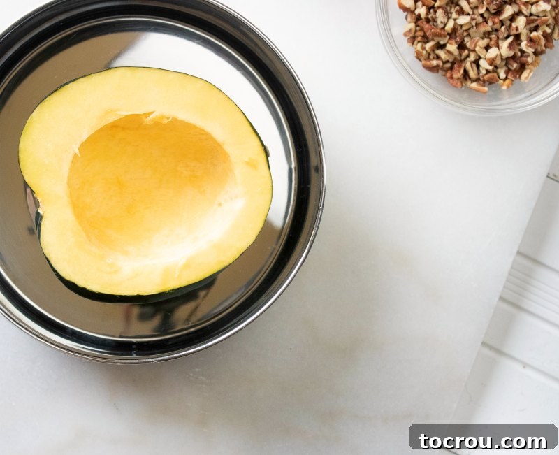 Half of an acorn squash with the seed removed, ready to be stuffed with a delicious filling.