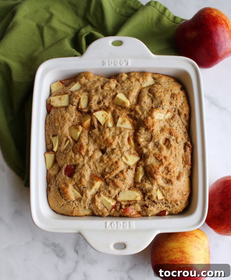 A freshly baked rustic buttermilk apple cake, golden brown and fragrant, just pulled from the oven.