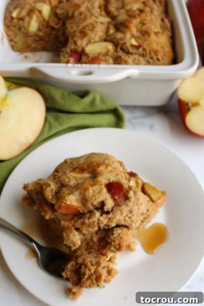 A delectable slice of rustic buttermilk apple cake on a plate, revealing abundant chunks of fresh apple, perfectly moist and ready to be savored.