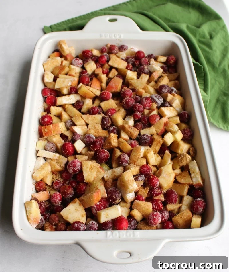 cranberries and apples tossed with brown sugar, cinnamon ready to bake into a crisp