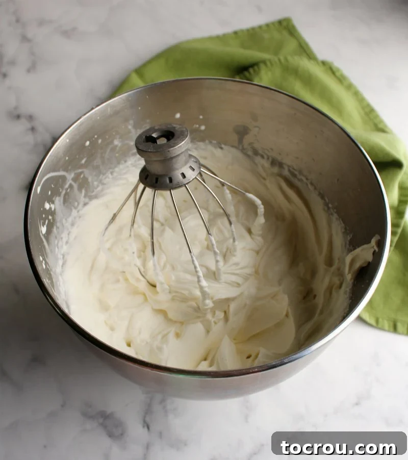 Luscious No-Bake Caramel Apple Cake 3 fluffy cream cheese whipped cream filling in mixer bowl for refrigerator cake.