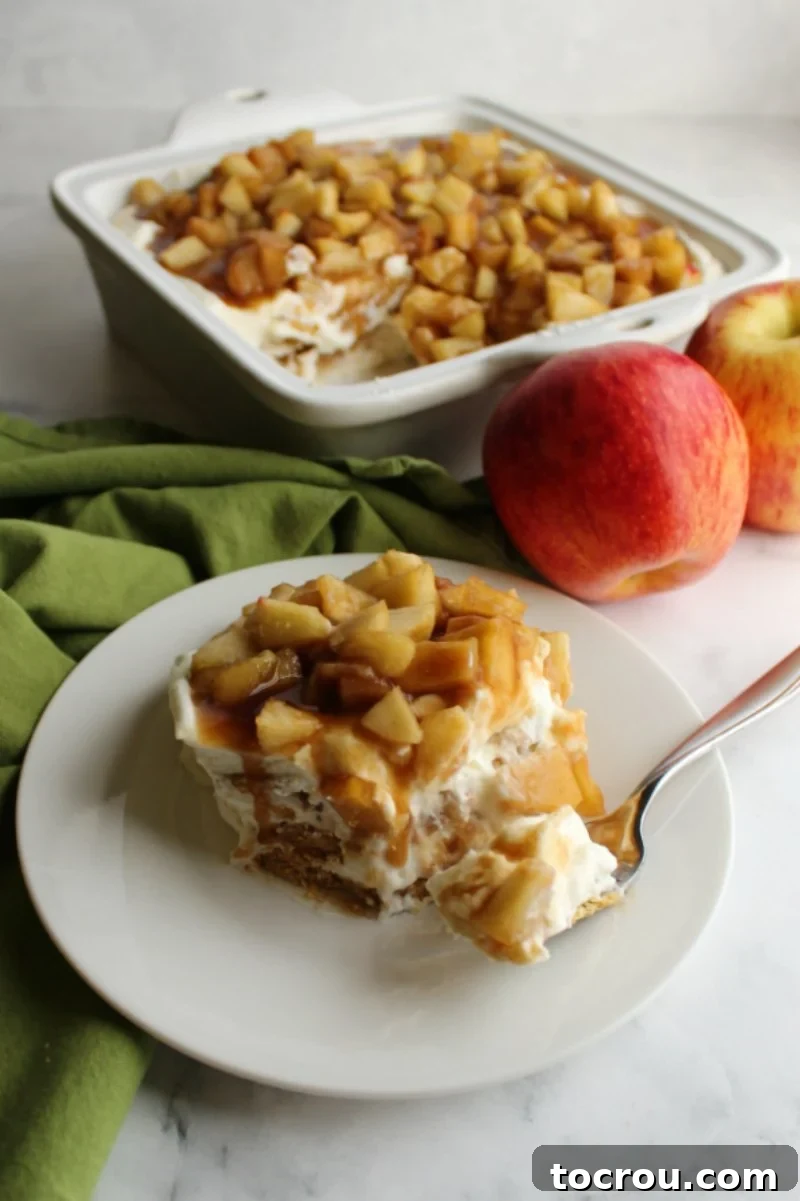 No bake creamy caramel apple icebox cake is a perfect way to transition to fall flavors without heating up the house. The vanilla cream cheese filling, Graham crackers and cinnamon brown sugar apples come together to make the perfect slice of dessert. piece of no bake cheesecake style caramel apple icebox cake