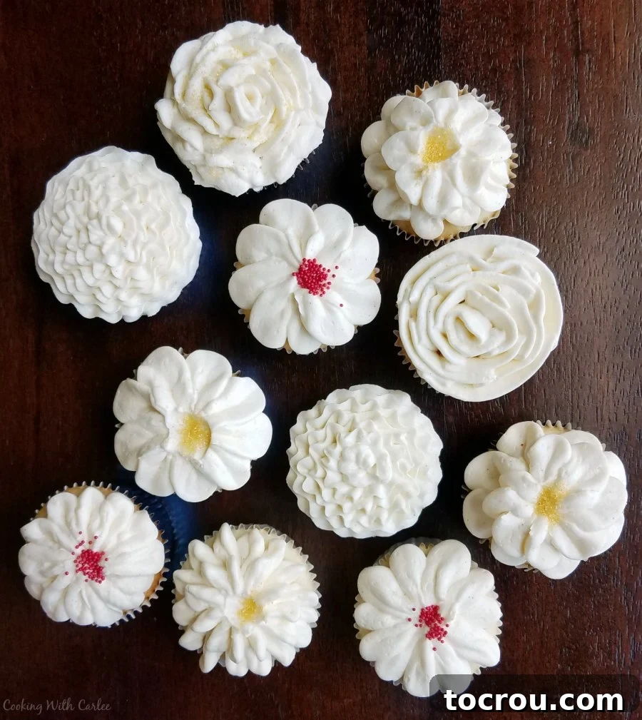 A delightful cupcake adorned with an array of intricately piped buttercream flower designs in vibrant and pastel colors, showcasing detailed artistry.