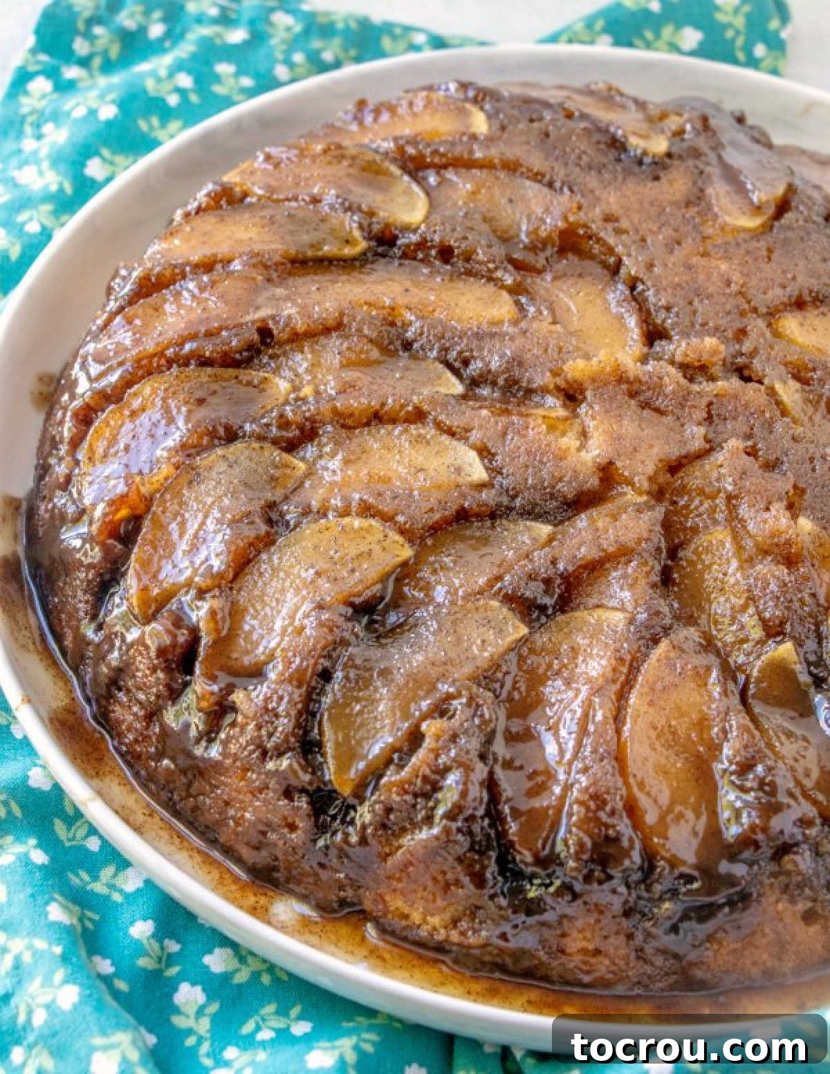 Gooey Caramel Apple Upside Down Cake 2 Caramel apple upside down cake freshly turned out of the pan onto a plate, showing cooked apples baked into the cake.