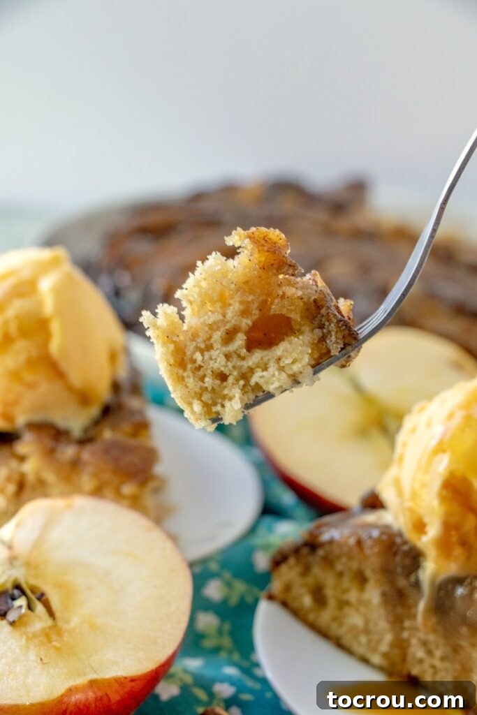 Gooey Caramel Apple Upside Down Cake 4 bite of caramel apple upside down cake in fork ready to eat.