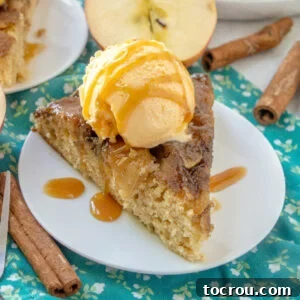 Gooey Caramel Apple Upside Down Cake 7 close slice of warm upside down caramel apple skillet cake with scoop of ice cream and drizzle of caramel sauce.