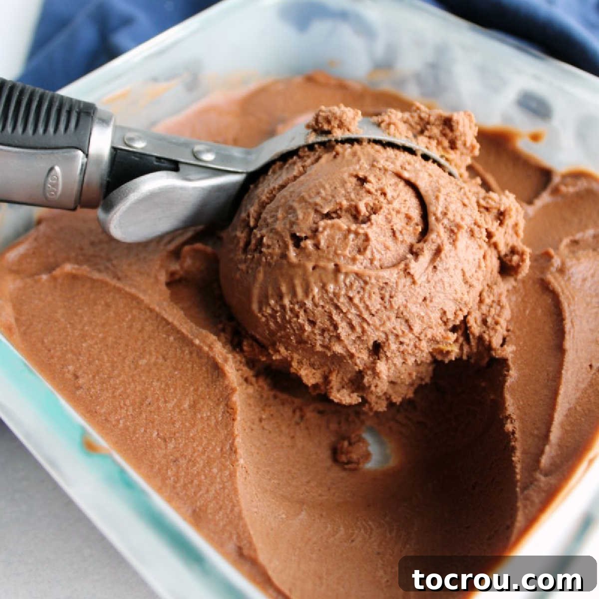 Chocolate Peanut Butter Nice Cream First Scoop A scoop of rich chocolate peanut butter nice cream being served, showcasing its smooth, creamy texture and deep brown color. Perfect for a healthy dessert.