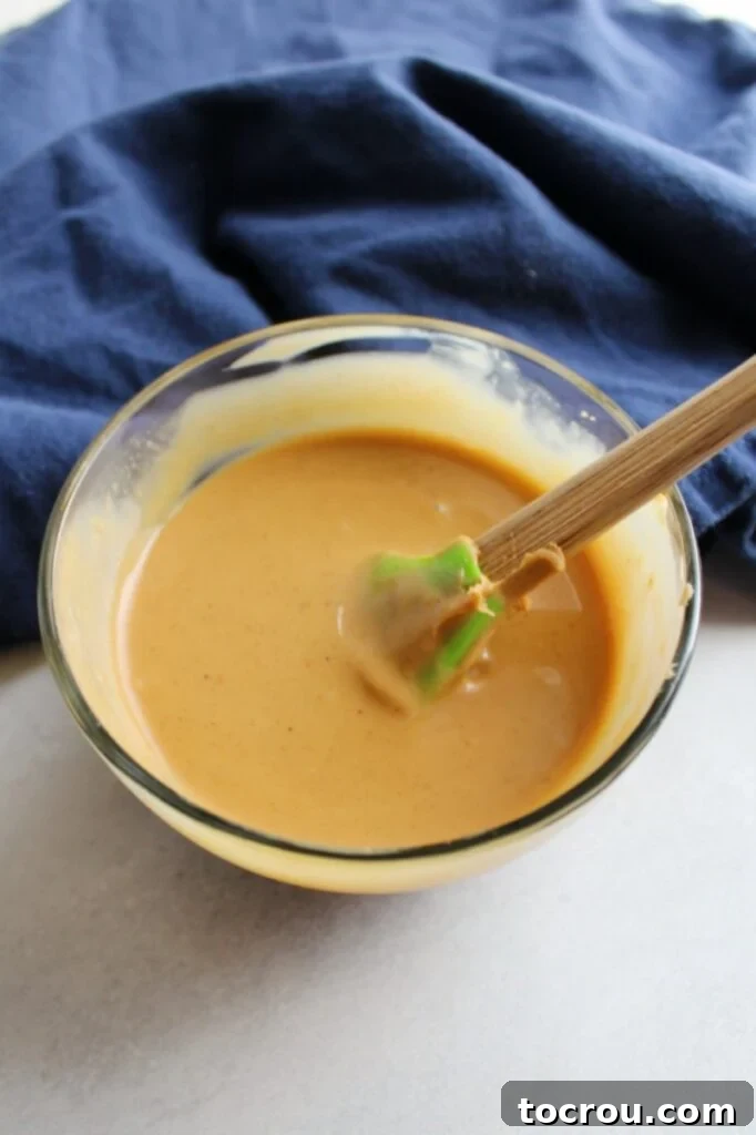 Bowl of creamy 2-ingredient peanut butter magic shell, perfectly smooth and ready to drizzle.