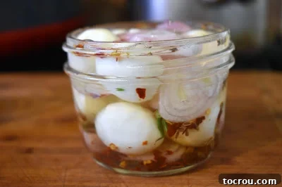 Pickled quail eggs in a glass jar, ready for snacking.