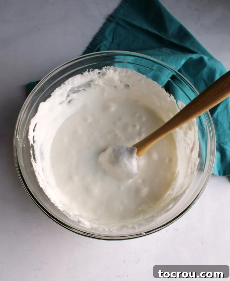 Marshmallowy Popcorn Delights 3 big glass bowl full of melted marshmallows and butter for popcorn balls.