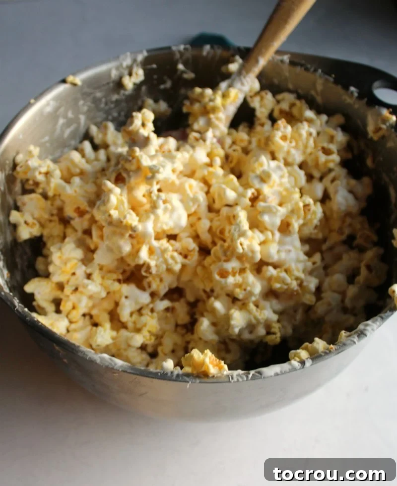 Marshmallowy Popcorn Delights 4 giant mixing bowl full of marshmallow coated popcorn.