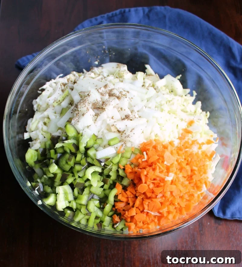 Big bowl of shredded cabbage, onions, peppers, carrots, and celery seed for coleslaw.