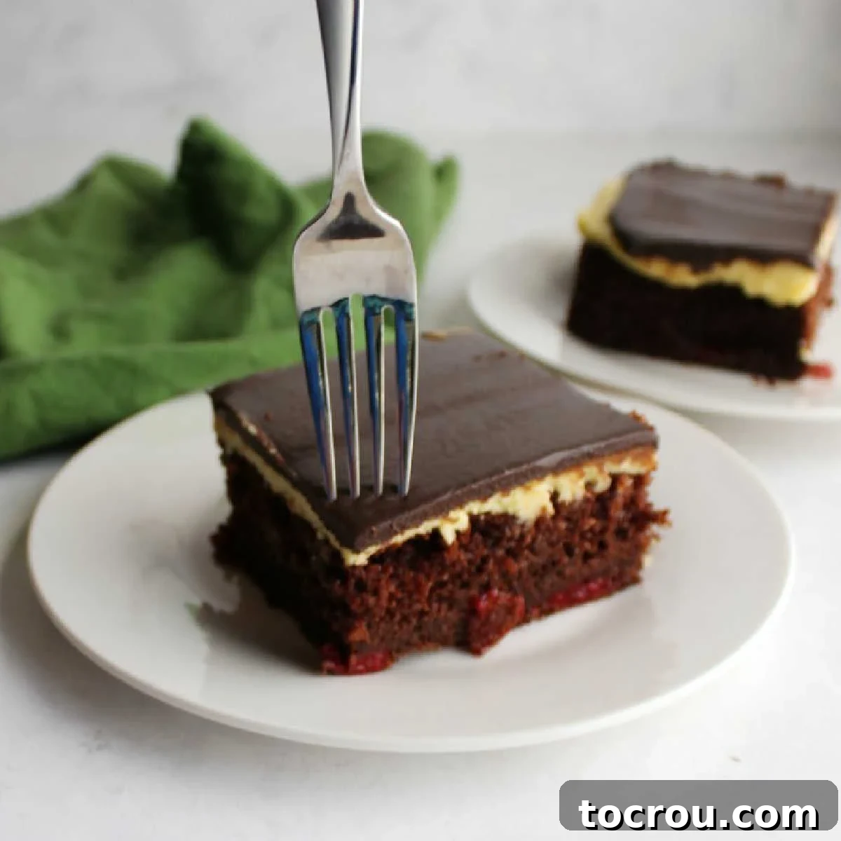 Decadent Black Forest Sheet Cake 10 A fork taking a delicious bite of chocolate cherry cake, revealing layers of moist cake, creamy buttercream, and rich ganache.