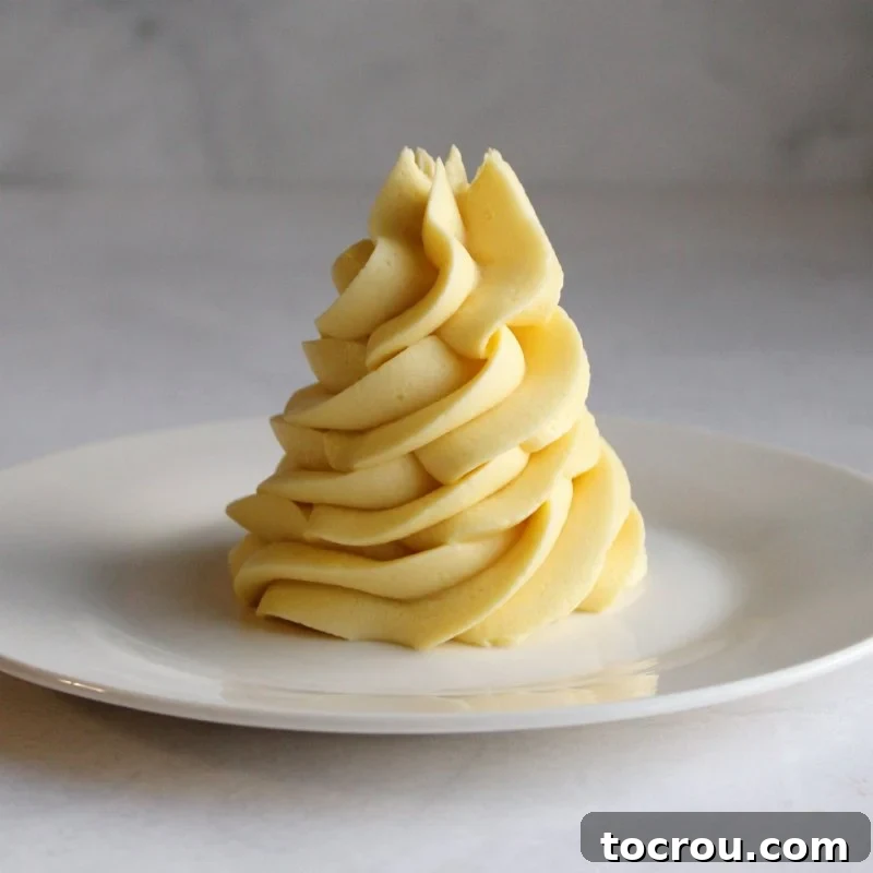 Classic Vanilla German Buttercream Swirls of creamy golden custard based German buttercream, showcasing its rich texture and color.