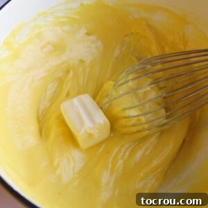 Beating a little bit of butter into custard mixture.