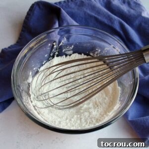 Small bowl of granulated sugar and cornstarch being whisked together for custard base.