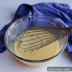 Small bowl with egg mixture tempered with warm milk.