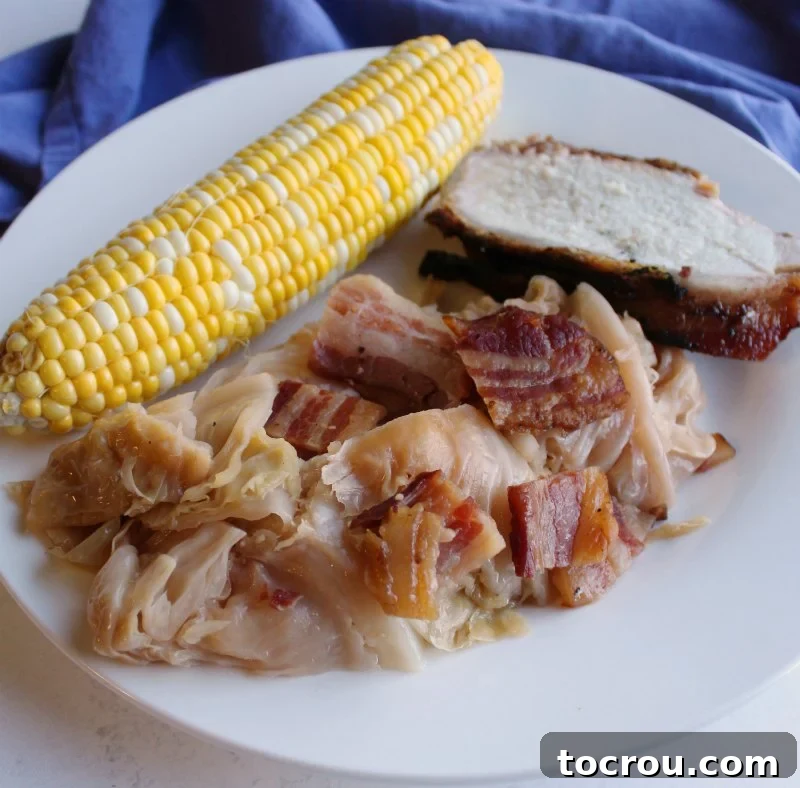 A whole head of cabbage wrapped in bacon and braised in beer is a thing of glory. Make it on the grill or in the oven for a flavorful side dish. dinner plate with cabbage, corn on the cob and bacon wrapped pork loin