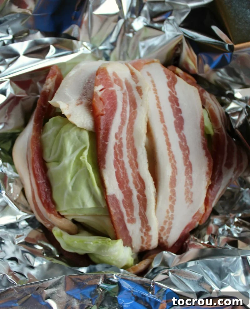 Beer Braised Cabbage Wrapped in Bacon 3 head of cabbage wrapped in bacon slices with aluminum foil around it