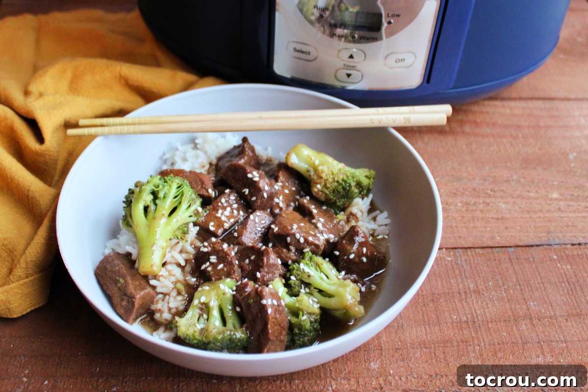 Make a take out inspired dinner in your slow cooker or instant pot. We love making this with venison backstrap, but beef works well too! Bowl of succulent venison and crisp broccoli stir-fry, served over fluffy white rice, with a slow cooker ready in the background. The dish is garnished with sesame seeds, evoking classic Chinese takeout.