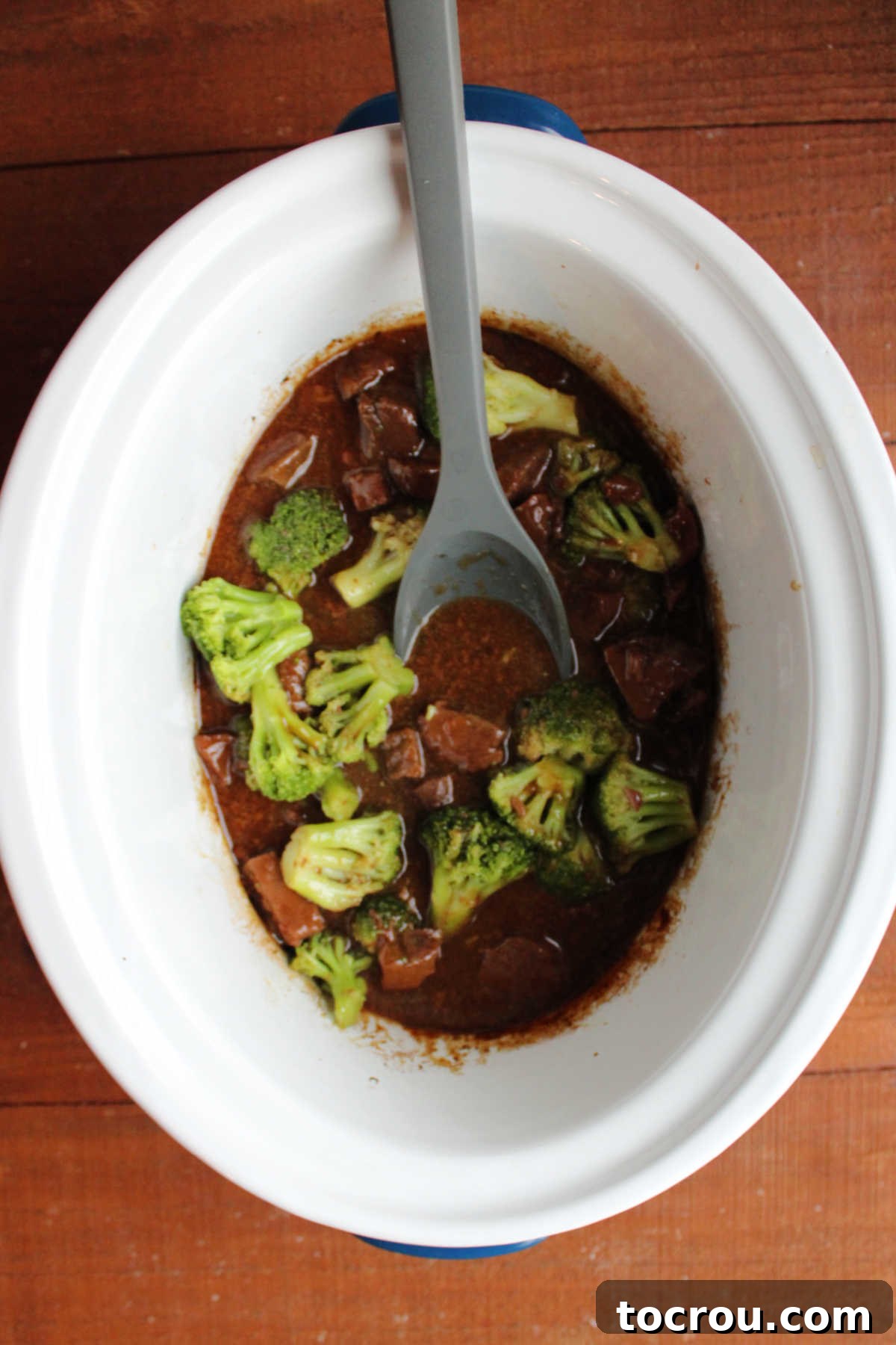Backstrap and Broccoli: Crockpot and Instant Pot Versatility 2 A slow cooker brimming with tender venison backstrap pieces and bright green broccoli florets, swimming in a rich, dark Asian-style sauce, ready to be scooped out.