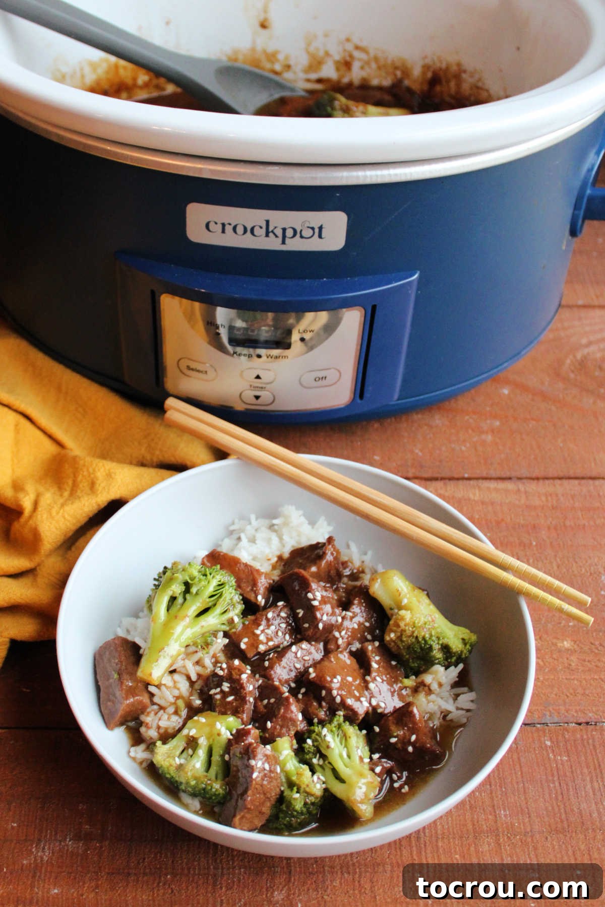 Backstrap and Broccoli: Crockpot and Instant Pot Versatility 3 A close-up shot of a serving of venison and broccoli, beautifully arranged over a bed of white rice, generously sprinkled with sesame seeds, highlighting the dish's enticing texture and presentation.