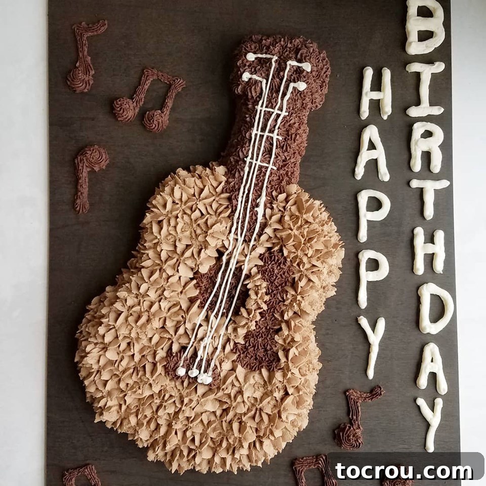 Cake shaped like a guitar with two tones of chocolate buttercream piped on it, showcasing detailed craftsmanship.