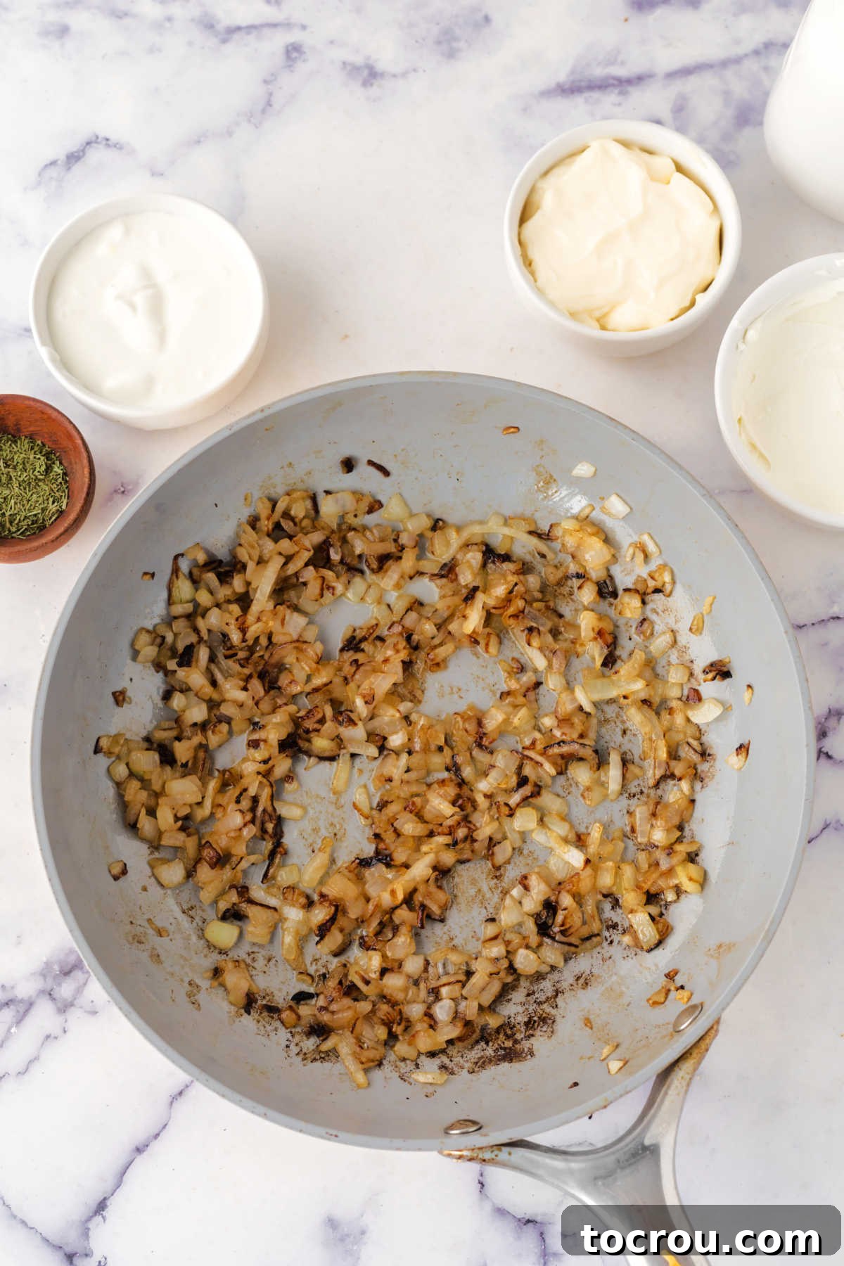 Caramelizing Onions in a Skillet to Golden Perfection Skillet with butter and caramelized onions inside showing their golden brown color and softened texture.