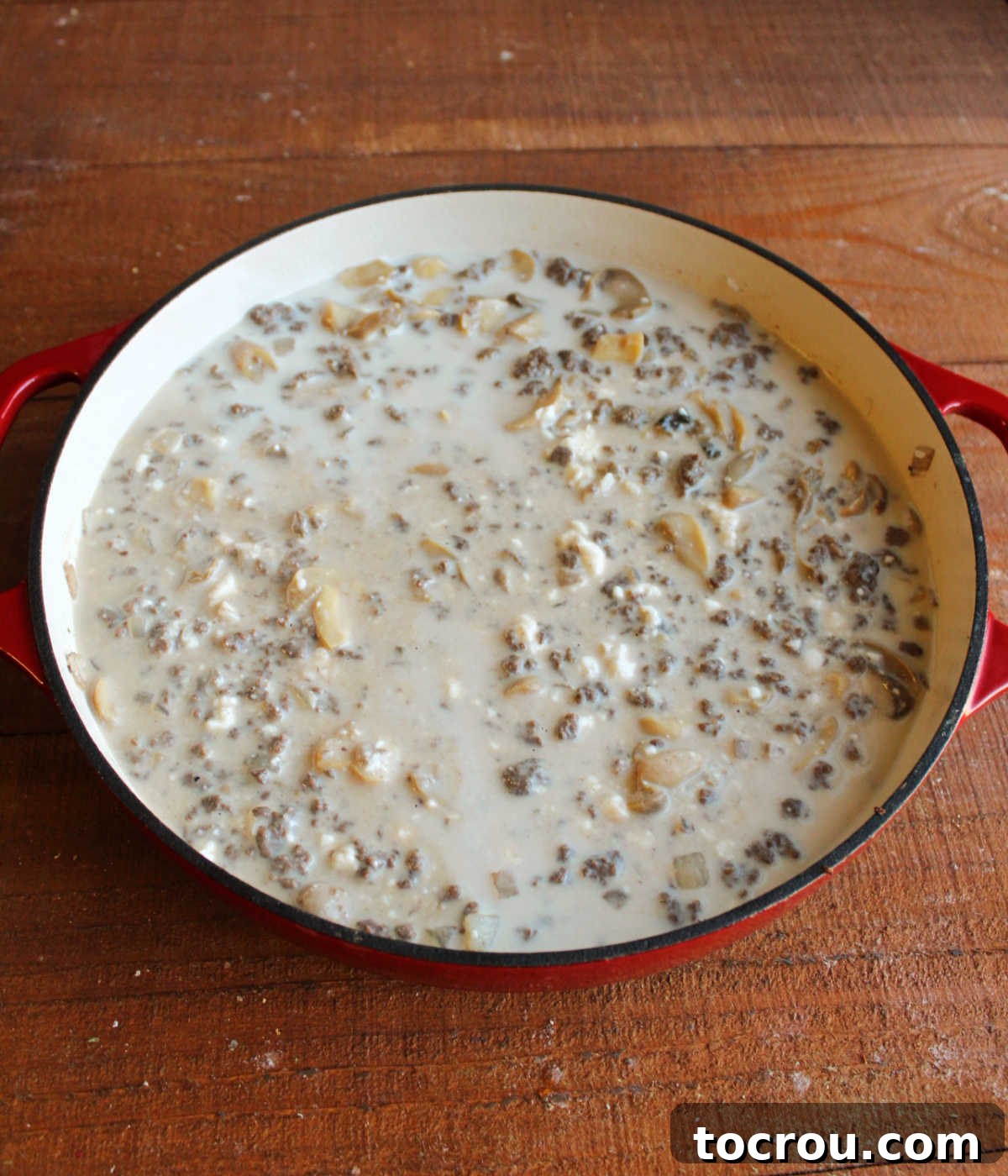 Hearty Creamy Venison Mushroom Rice 6 Pan with soup, mushrooms, water, milk, and soy sauce stirred into the rice and venison showing all of the extra liquid.