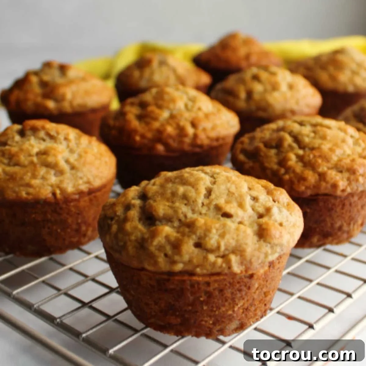 A batch of soft, golden-brown banana oatmeal muffins cooling on a wire rack, ready to be enjoyed.