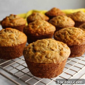 Batch of soft banana oatmeal muffins on wire cooling rack.