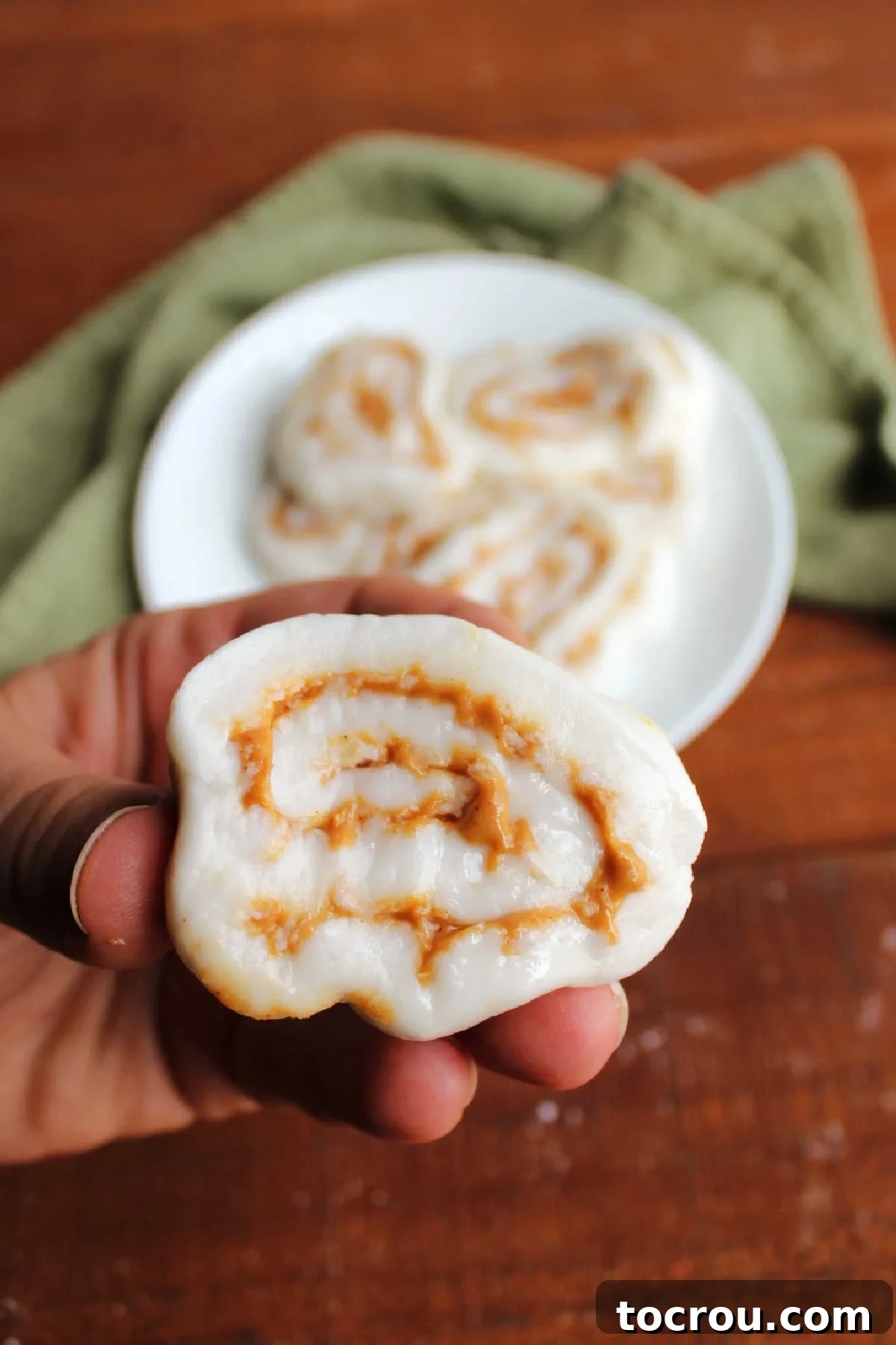 Potato Candy Ready to Eat Hand holding a piece of potato candy with a swirl of peanut butter, ready to eat.