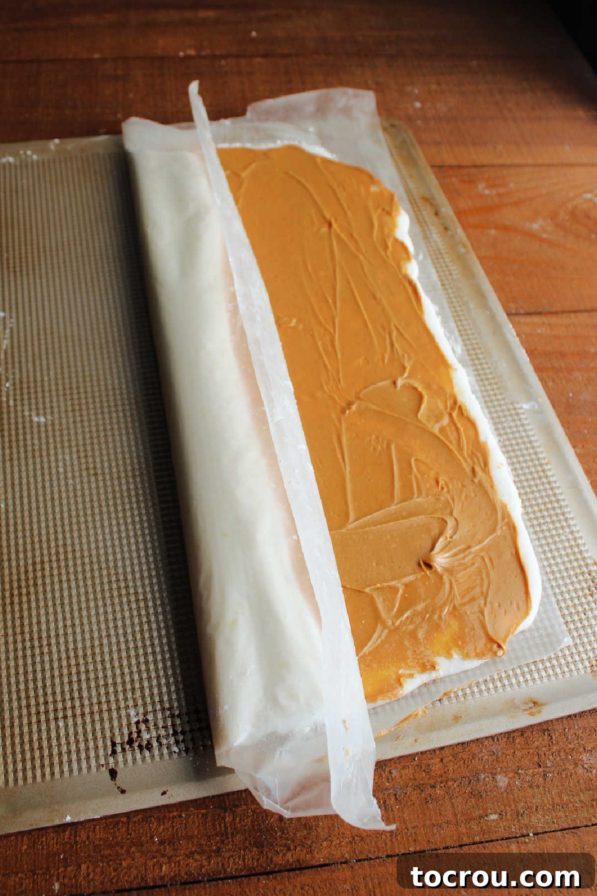 Rolling Potato Candy Using wax paper to roll the peanut butter and mashed potato layers into cinnamon roll like spirals.