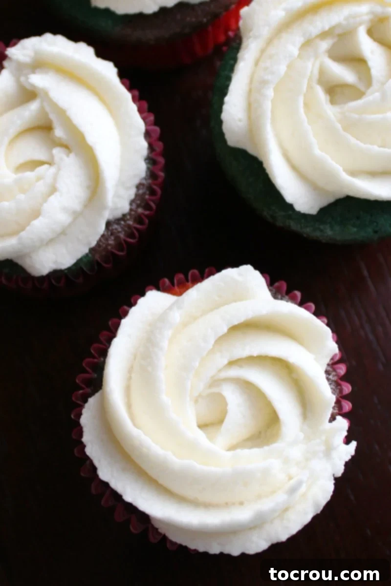 Elegant cream cheese frosting rosettes decorating the tops of cupcakes.