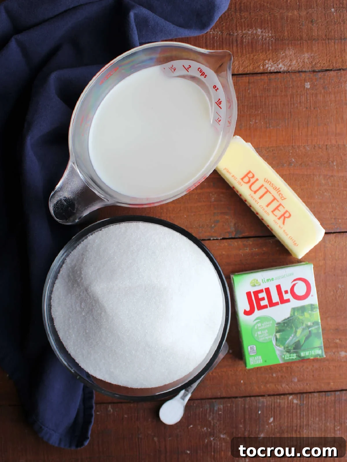 Ingredients including sugar, milk, butter, lime Jell-o, and baking soda ready to be made into fudge.