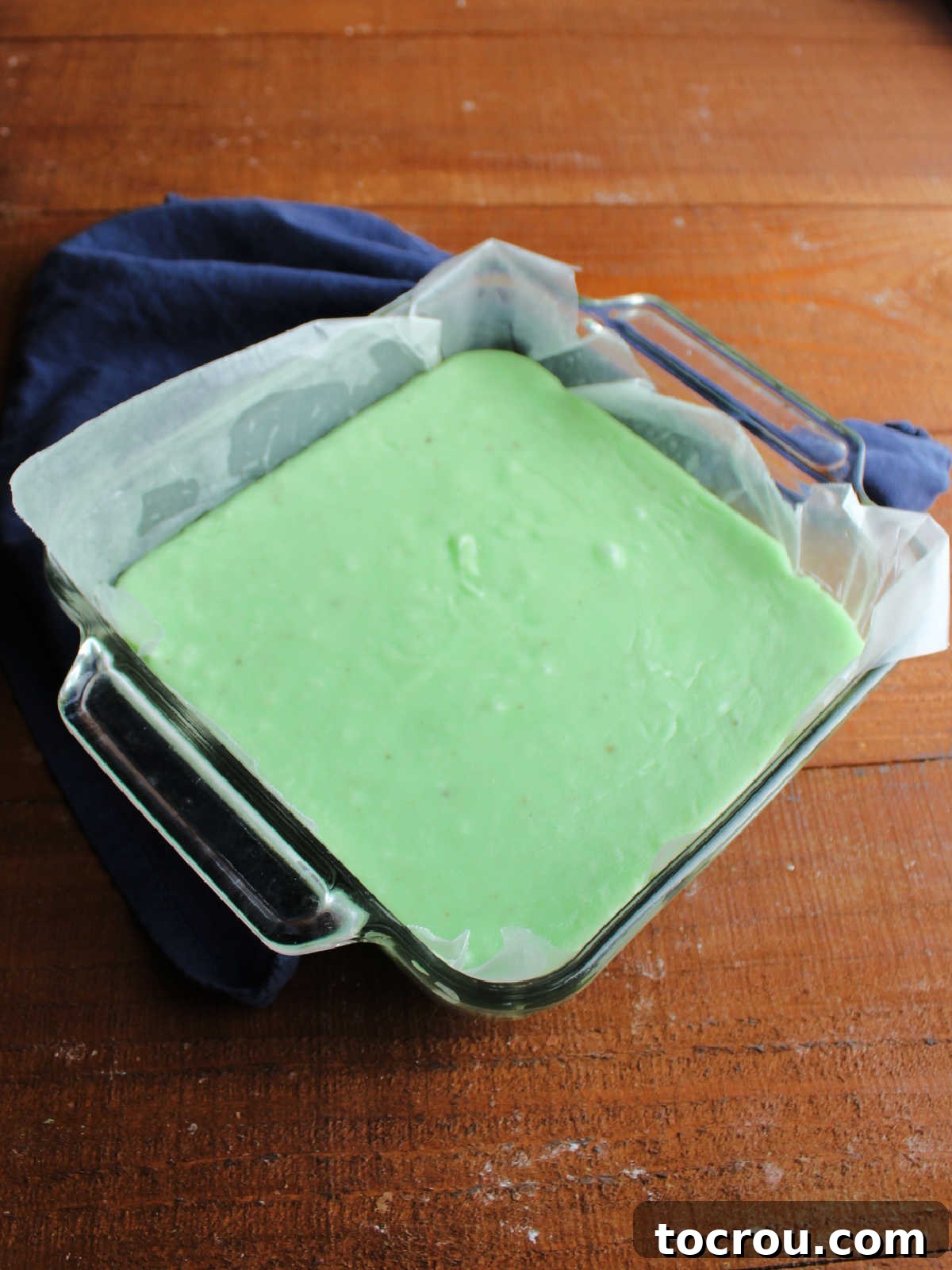 Square pan with green jello fudge inside.