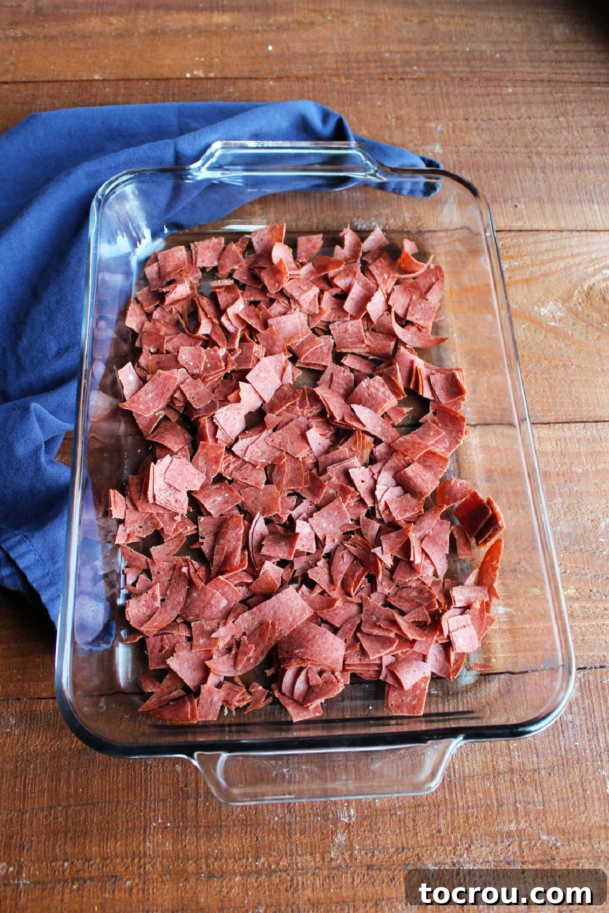 Chopped dried beef in the bottom of a glass 9x13-inch pan.