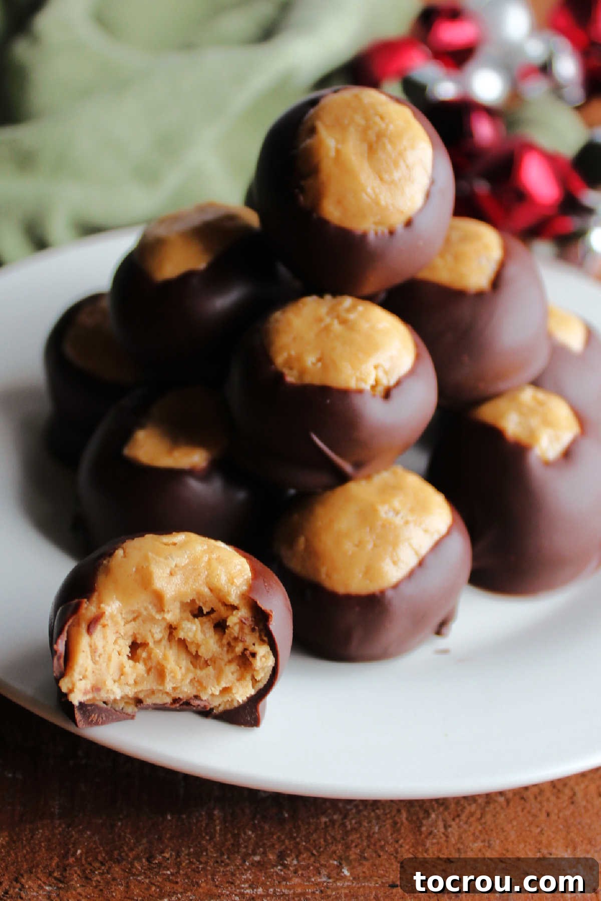 Rice Krispie Crunch Buckeyes 3 Crunchy buckeye half showing rice krispie and peanut butter center with chocolate coating.