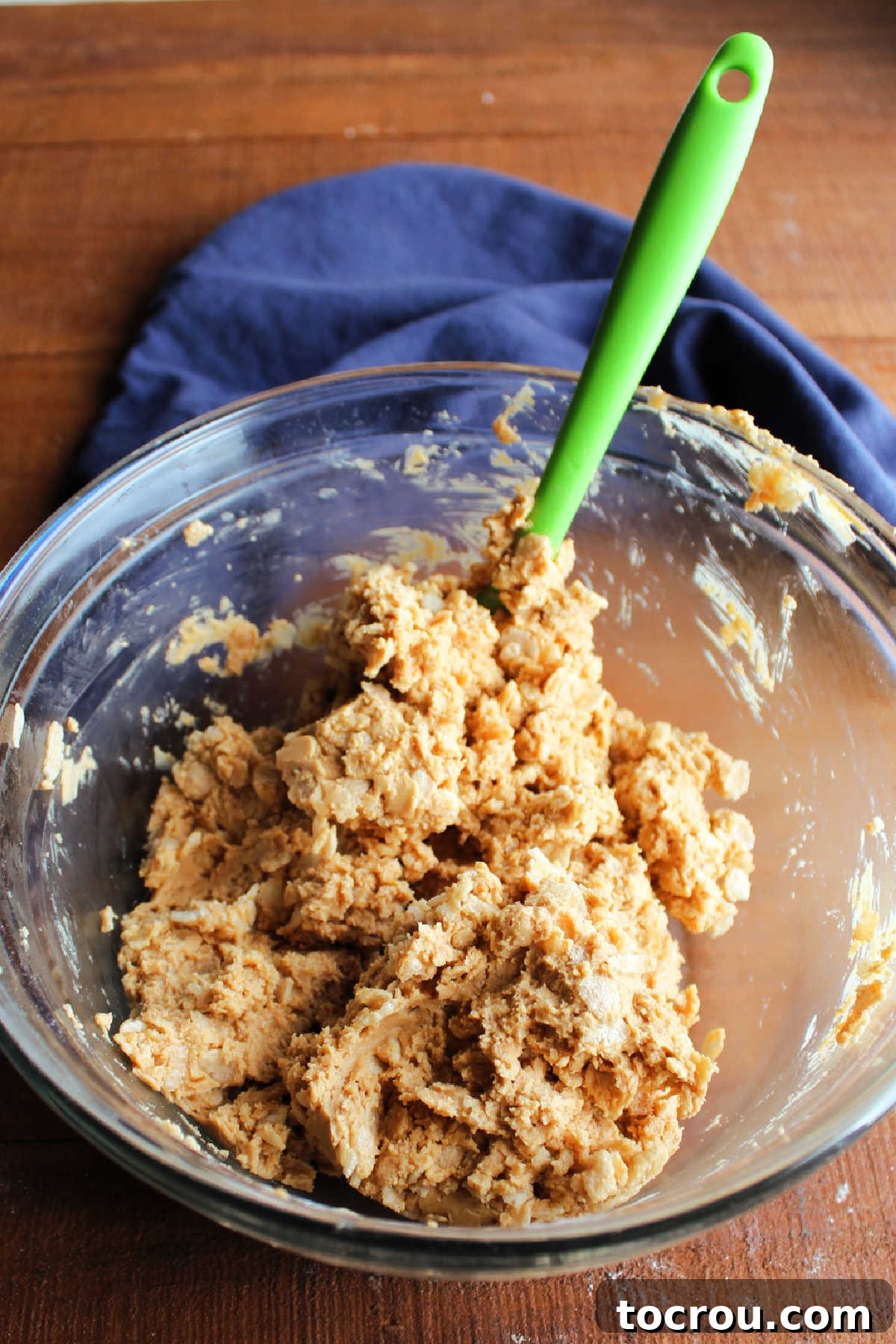 Rice Krispie Crunch Buckeyes 6 Mixing bowl with spatula folding crisp rice cereal into the peanut butter mixture.