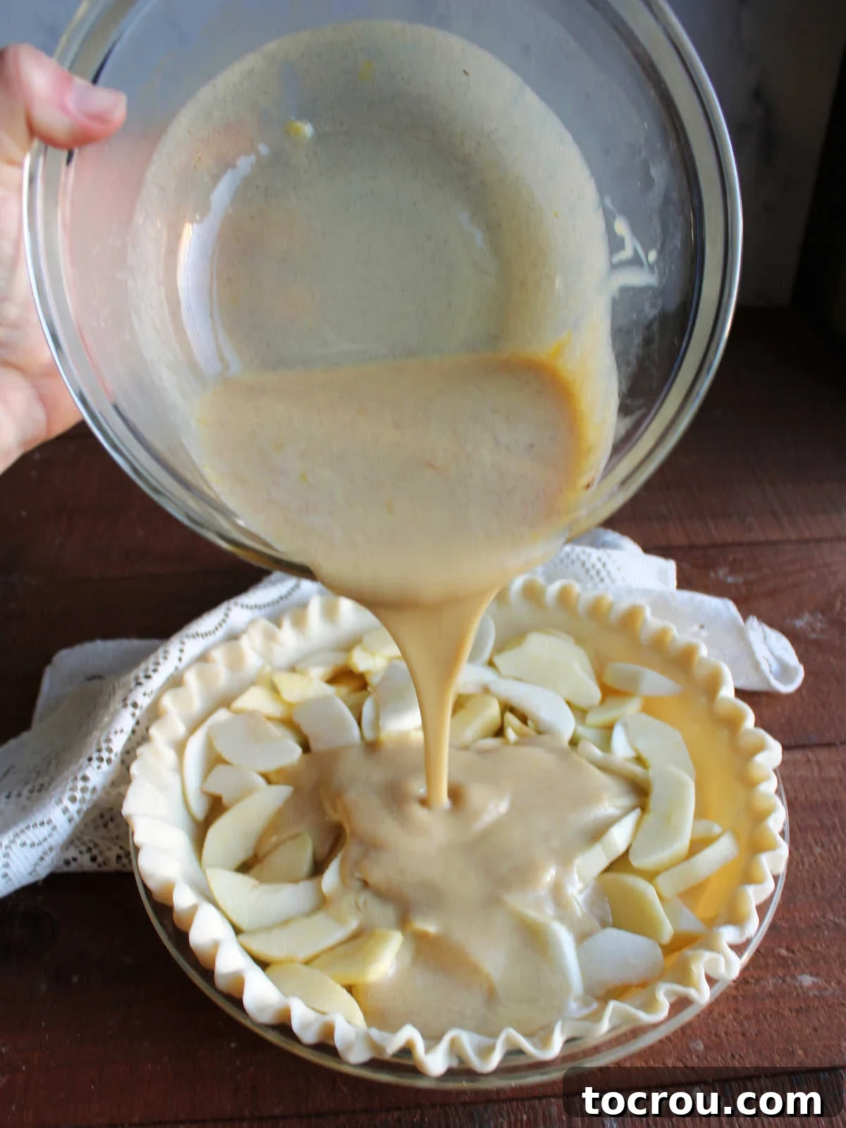 Apple Custard Crumble Pie 8 Pouring condensed milk custard over apple slices in pie plate.