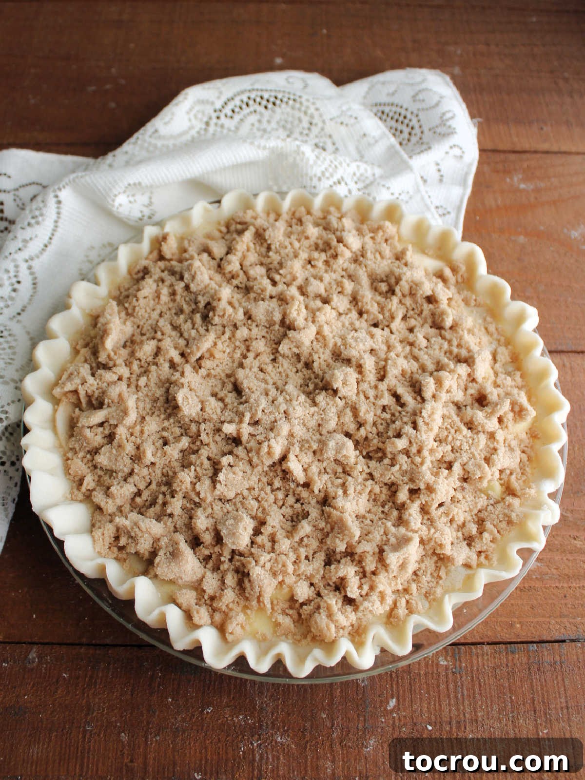 Apple Custard Crumble Pie 10 Pie covered in brown sugar streusel mixture, ready to go in the oven.
