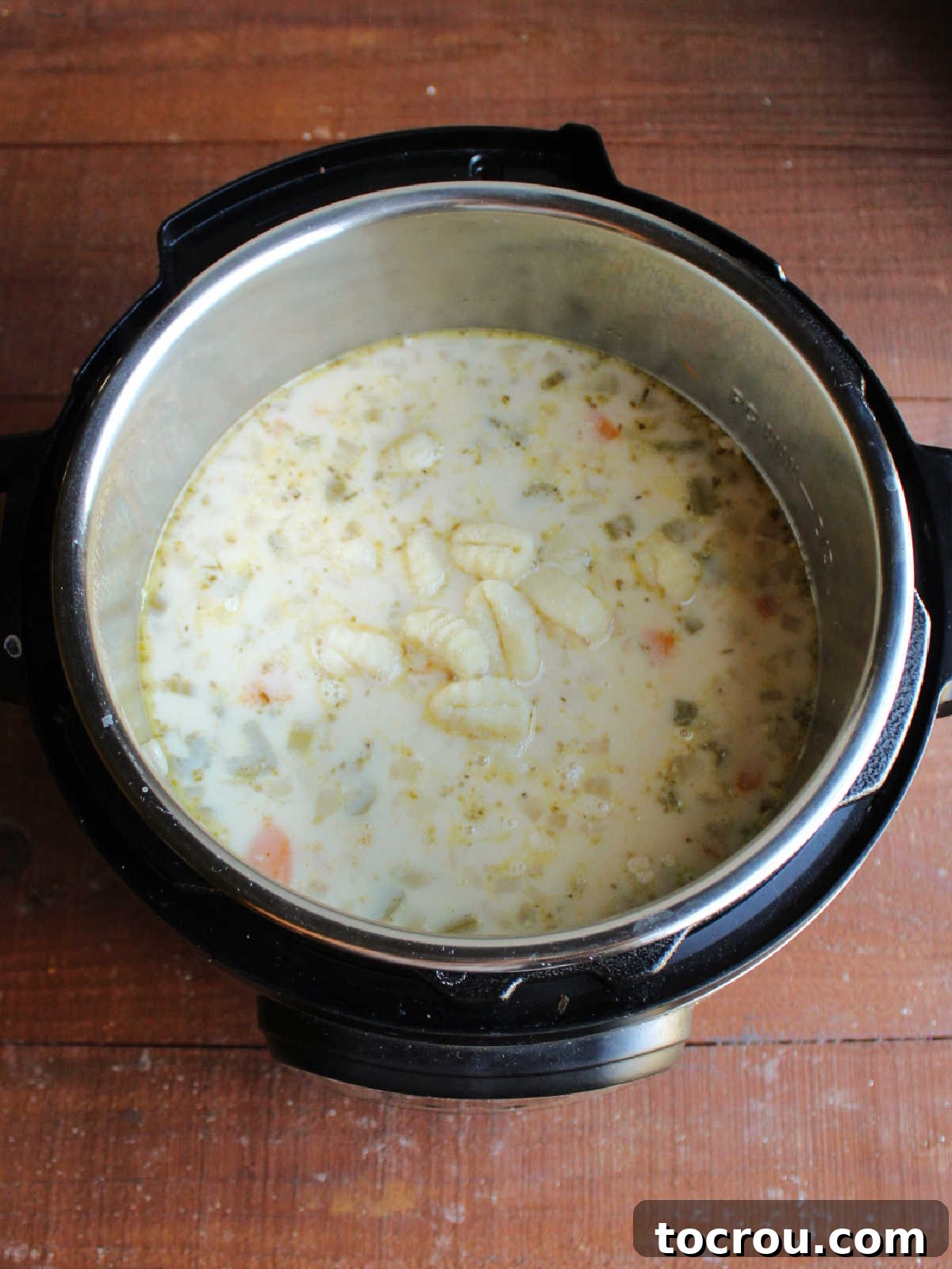 Instant pot after evaporated milk, cornstarch slurry and gnocchi have been added, ready to be cooked more.